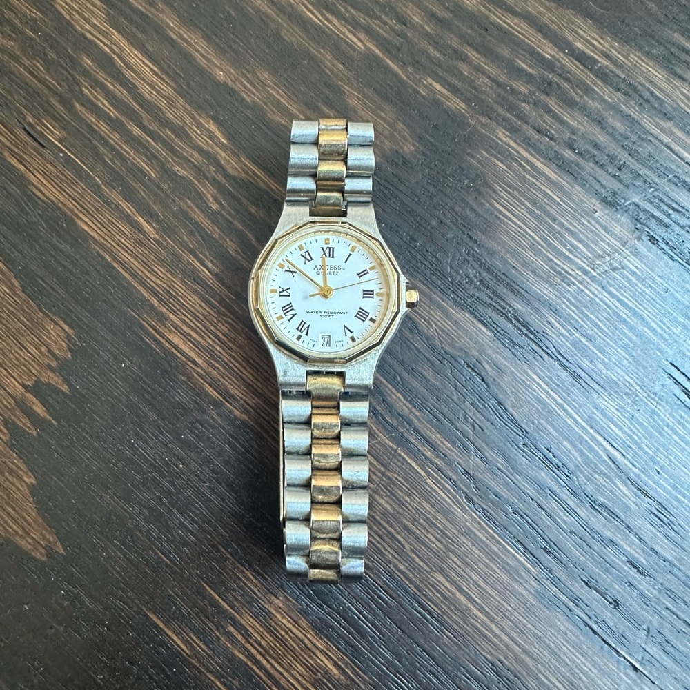 Vintage Axcess Quartz two-tone watch with Roman numerals and a date display.